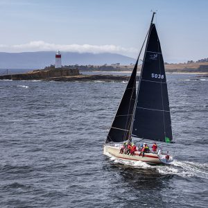 Cinquante 2019. Foreground, middle ground and background are compositional considerations in a strong image. Here we can see Mount Wellington behind the finishing line at Castray Esplanade. The Iron Pot lighthouse, a signature landmark in the race, looks tall because of the low camera angle and Cinquante skippered by Kim Jagger is powering towards the last corner at the mouth of the Derwent estuary